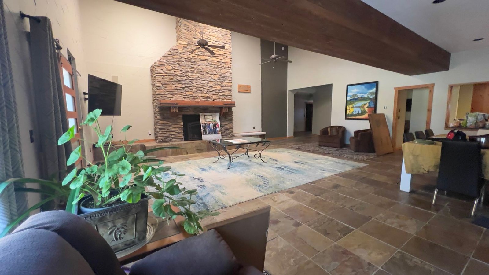 Great room with a stone fireplace and tall beamed ceiling