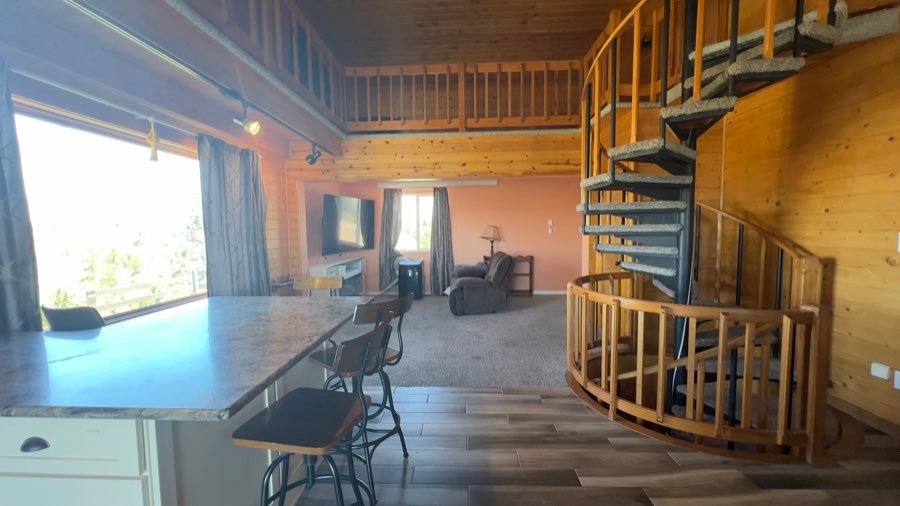 Loft living area with a spiral staircase and breakfast bar
